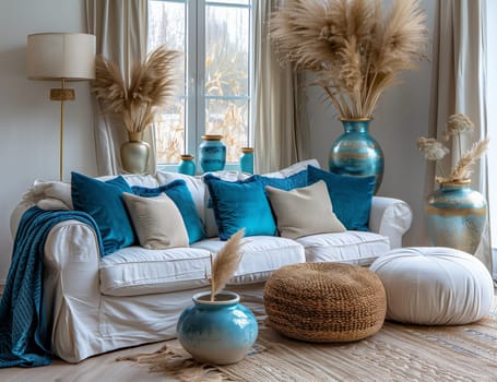 A living room with a white couch, azure pillows, vases, and ottomans. The interior design features wooden furniture and a white floor in a modern house
