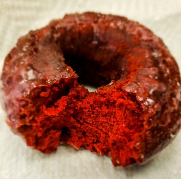 View of a Partially-eaten Red Velvet Donut Sitting on a Paper Napkin