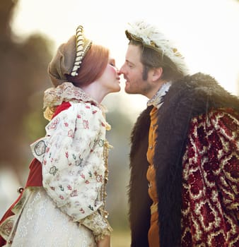 Medieval, king and couple kiss in history with renaissance fashion outdoor with marriage and love. Vintage, garden and royal leader with queen together on a lawn with romance and theater costume.