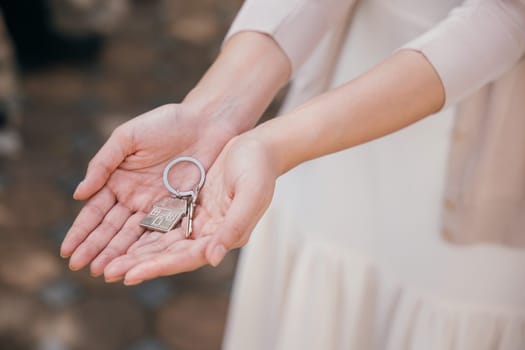 Happy woman landlord handing over keys signifying property deal success and tenant security. Real estate concept portrays new beginnings and investment achievement. Give me the key