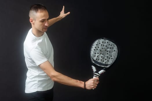 Padel Tennis Player with Racket in Hand. Paddle tennis, on a black background. High quality photo