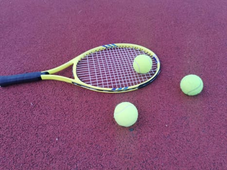 Tennis. Tennis ball and racket on a red background of tennis court with copy space. Sport and healthy lifestyle. The concept of outdoor game sports. . High quality photo