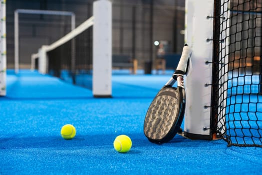 Paddle tennis racket, ball and net on the court . High quality photo