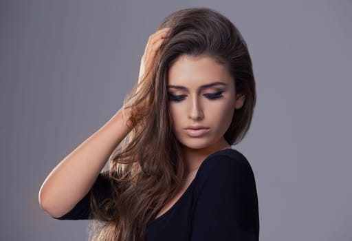 Aesthetic, hair care and woman with beauty, texture and treatment on a grey studio background. Wellness, person and model with shampoo and keratin with makeup and cosmetics with shine and glowing.