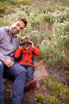 Dad, child and binoculars with smile from hiking, travel and watching in nature with adventure. Parent, youth and father with love, support and trust outdoor with fun and view on trip with walking.