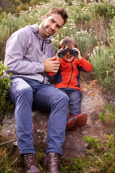 Dad, child and camping binoculars with smile from hiking, travel and watching in nature with adventure. Backpack, youth and father with love, support and trust outdoor with a smile from walking.