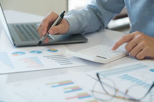 An accountant in is using a calculator to calculate bill income and investment information to manage the financial budget used for investment