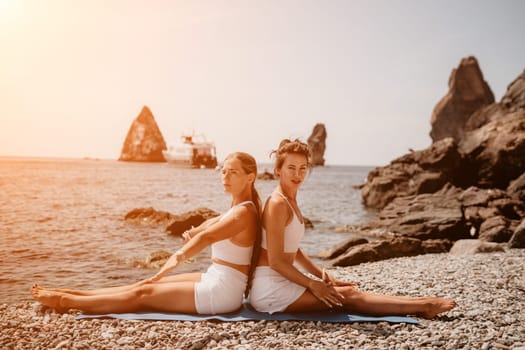 Woman sea yoga. Back view of free calm happy satisfied woman with long hair standing on top rock with yoga position against of sky by the sea. Healthy lifestyle outdoors in nature, fitness concept.