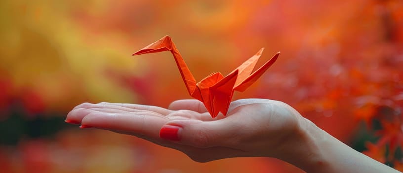 Hand holding an origami crane, symbolizing peace, creativity, and patience.