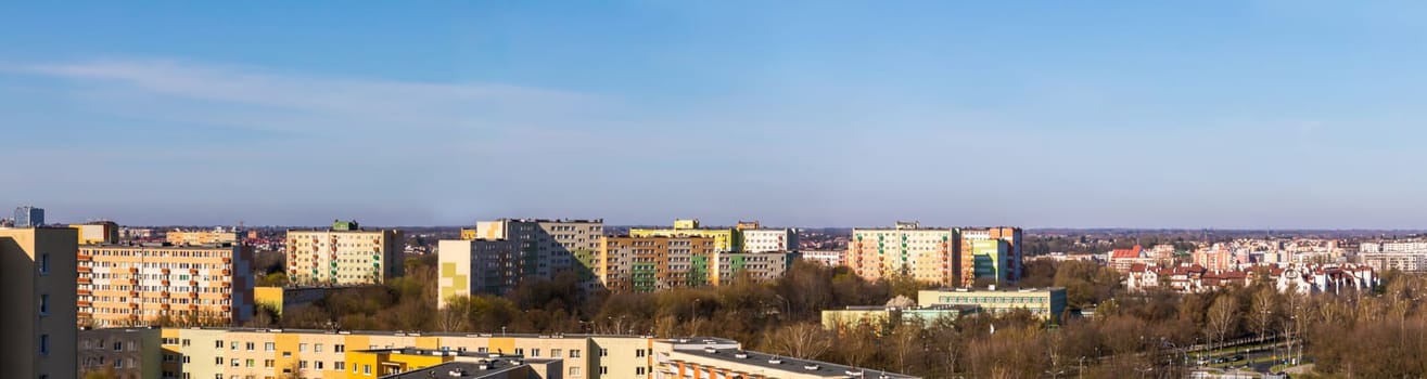 The whole city is bathed in the morning sun as part of Lublin's panorama. Lots of skyscrapers and lower buildings sufficient among the trees in early spring.