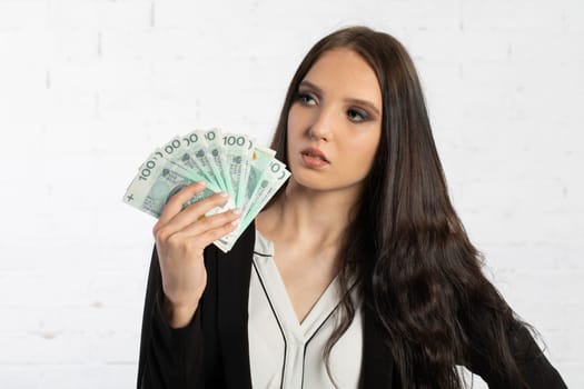 A young successful woman is holding a large amount of cash.