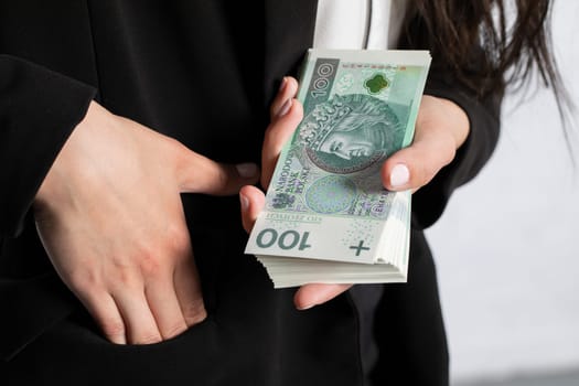 Close-up shot of banknotes and a woman's hand.