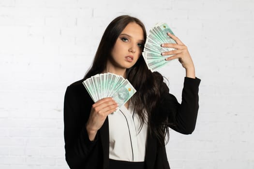 A young successful woman is holding a large amount of cash.