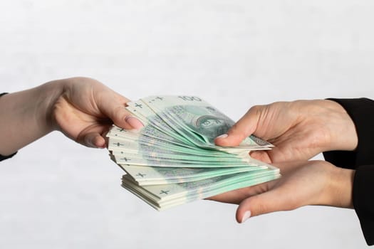 Spread-out fan-shaped paper banknotes hold young woman's hands.