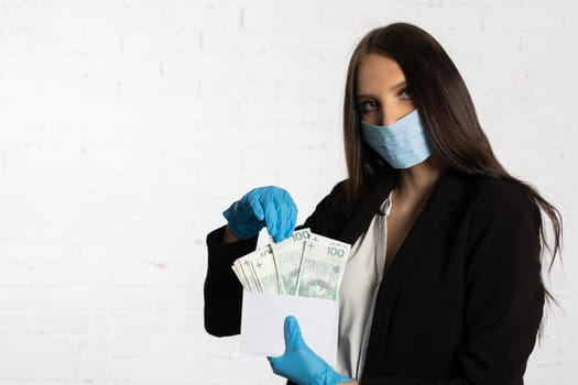 The woman slips a bundle of one hundred Polish zloty banknotes into a white envelope.