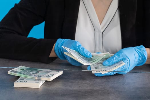 During an ongoing epidemic of infectious disease, the cashier gives cash in protective gloves.