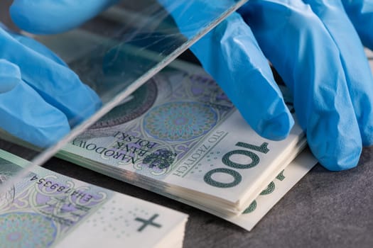 During an ongoing epidemic of infectious disease, the cashier gives cash in protective gloves.