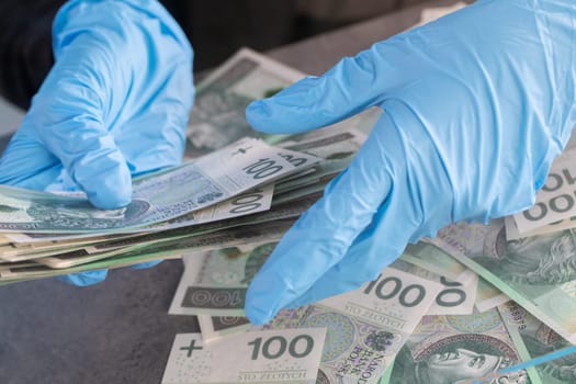 During an ongoing epidemic of infectious disease, the cashier gives cash in protective gloves.
