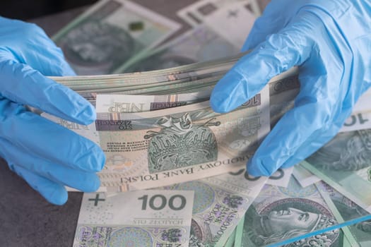 During an ongoing epidemic of infectious disease, the cashier gives cash in protective gloves.