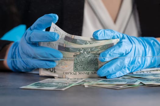 During an ongoing epidemic of infectious disease, the cashier gives cash in protective gloves.