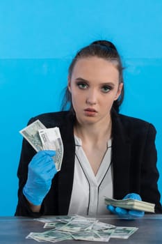 The cashier has randomly distributed banknotes on the desk behind the glass and tries to count them all exactly.