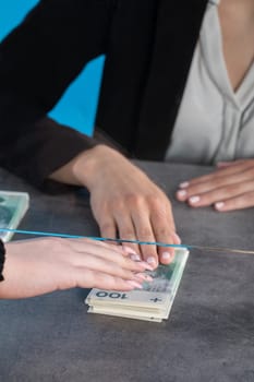 At a bank position, an employee accepts large sums of money from a young woman.