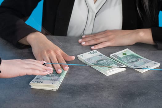 At a bank position, an employee accepts large sums of money from a young woman.