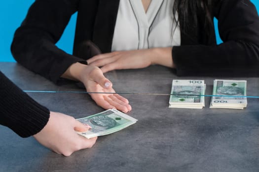 At a bank position, an employee accepts large sums of money from a young woman.