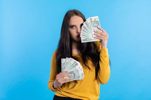 The teenager holds a large sum of money in her hand and is ready to give it to her.