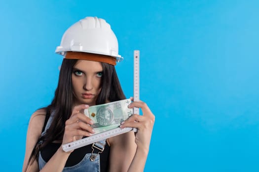 A woman in a hard hat holds a bundle of banknotes in her hand and encourages cooperation.