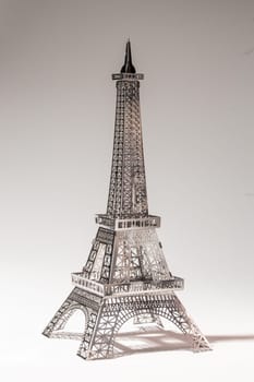 Metal Eiffel Tower cutout on white background. Lattice design highlights skill and precision, creating intricate pattern.