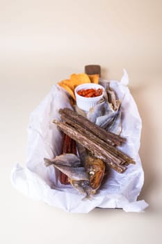 The smoked fish includes salmon, trout, and whitefish. The fish is served on a wooden board with a bowl of red pepper flakes.