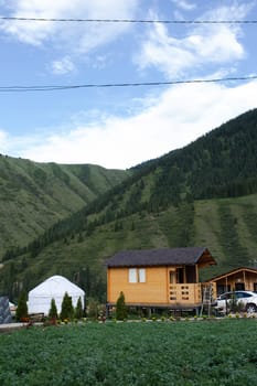 Wooden sauna in summer at the house with a mountain landscape in the background.