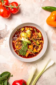 Red curry with veggies, tofu on a white background. Made with coconut milk, red curry paste, garnished with sesame seeds.