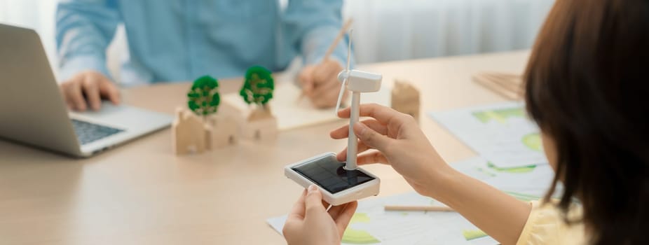 Businesswoman interested in investing in renewable energy at meeting table with environmental document scatter around. Business team discussion about green business project. Closeup. Delineation.