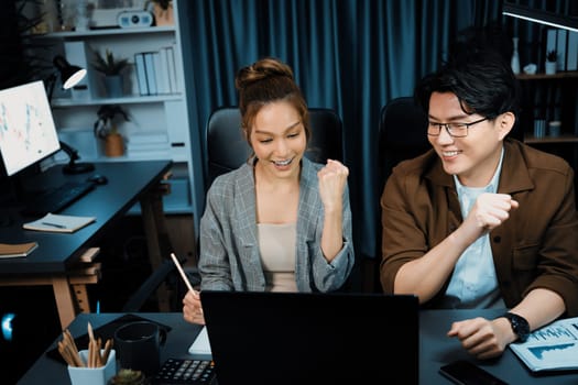 Smiling businesswoman trader with partner discussing on stock market trading exchange in casual suit, getting highest profit trading value financial technology investment at office at night. Infobahn.