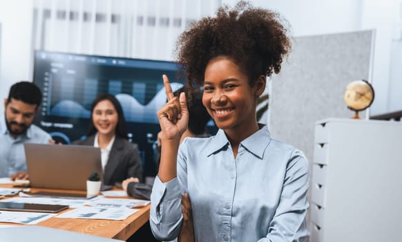 Portrait of happy young african businesswoman with group of office worker on meeting with screen display business dashboard in background. Confident office lady at team meeting. Concord