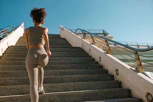 Athletic woman in sportswear is jogging around the city in early morning. Reaching the goal