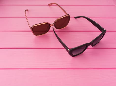 Summer abstract background mockup template free copy space for text pattern sample top view above on pink wooden board. blank empty area for inscription. Couple Stylish black sunglasses fashionable