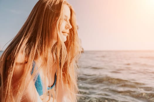 Close up shot of happy young caucasian woman looking at camera and smiling. Cute woman portrait in bikini posing on a volcanic rock high above the sea
