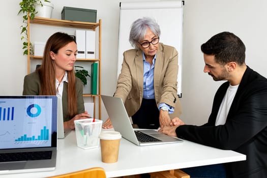 Senior female boss talking to employees in the office.Business concept.