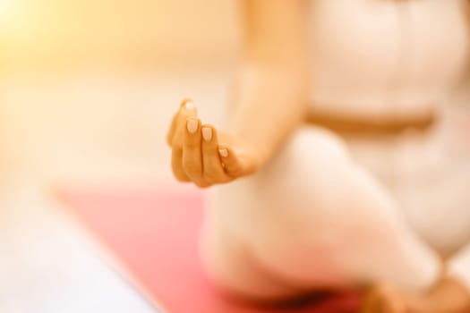 Girl does yoga. Young woman practices asanas on a beige one-ton background