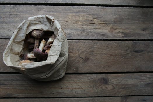 Mushrooms in a paper bag on a old vintage table. Menu background.