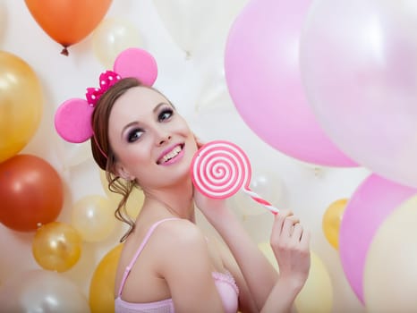 Portrait of smiling comely girl posing with lollipop