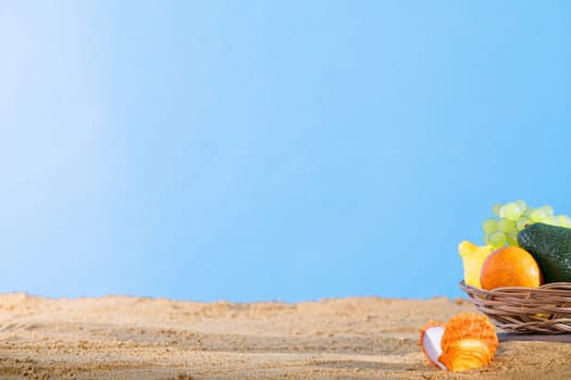 Blue sky over the sea beach. Ripe southern fruits lie in the basket. Sea shore of a sandy beach.