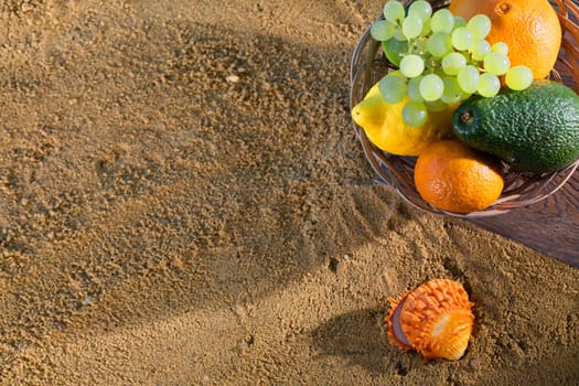 Ripe southern fruits lie in the basket. Sea shore of a sandy beach.
