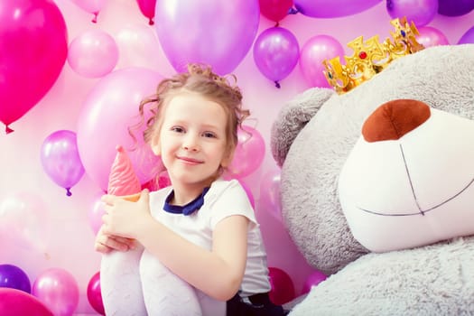Smiling little girl posing with ice cream in playroom