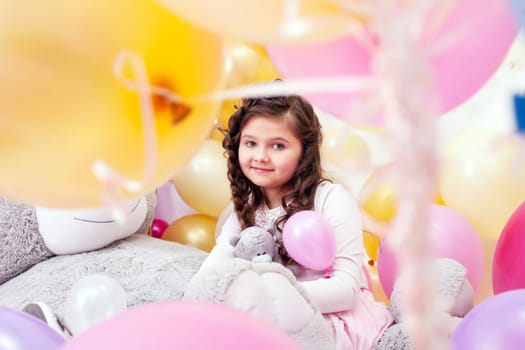 Studio shot of smiling little brunette looking at camera