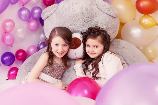 Lovely little girlfriends posing with big teddy bear