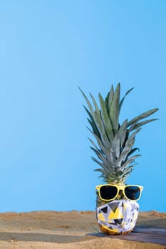 Ripe pineapple. Protective mask. Sunglasses with a yellow frame. Sea beach. Sunny day.